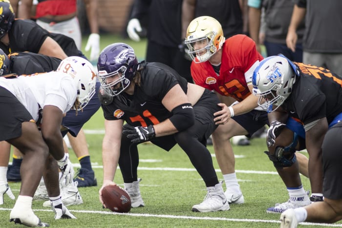 National offensive lineman Quinn Meinerz of Wisconsin -Whitewater (71) gets set with National quarterback Ian Book of Notre Dame (12) in drills during National team practice during the 2021 Senior Bowl week.